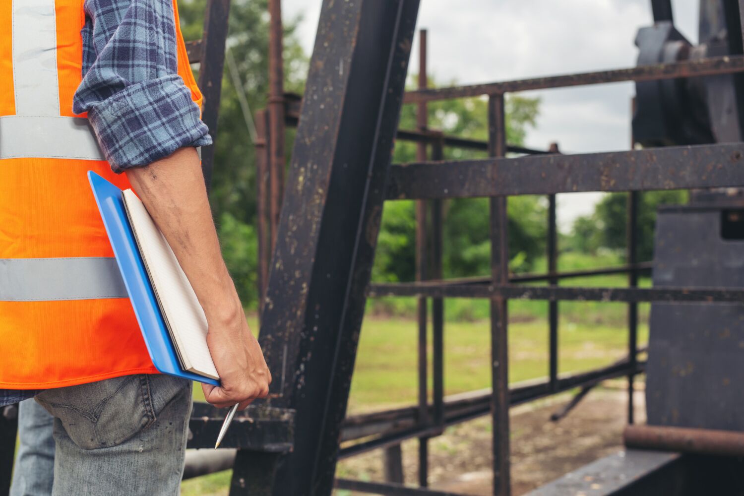 Inspector holding a folder beside a steel structure on a job site