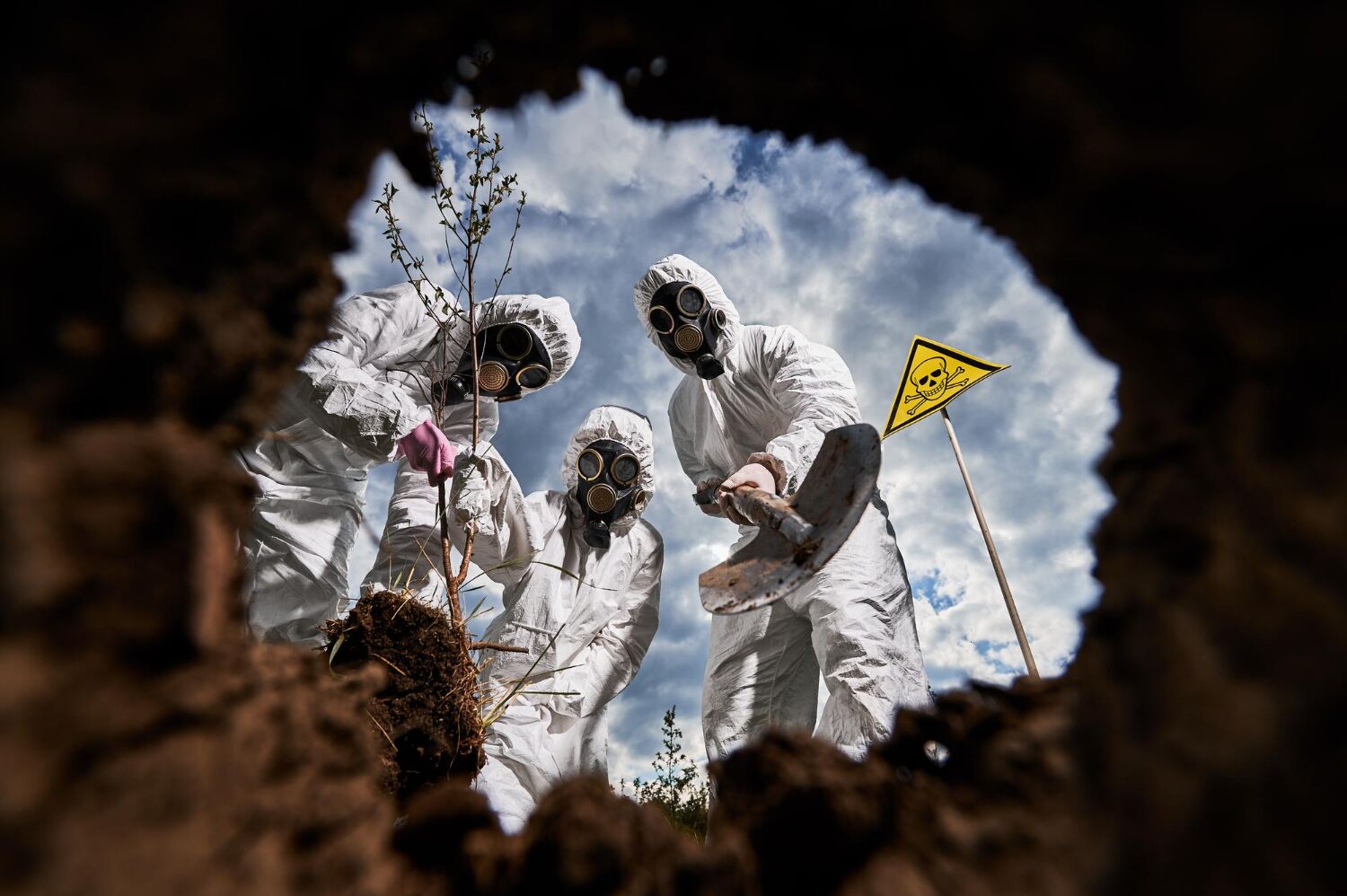 Workers in protective suits taking samples in an excavated pit